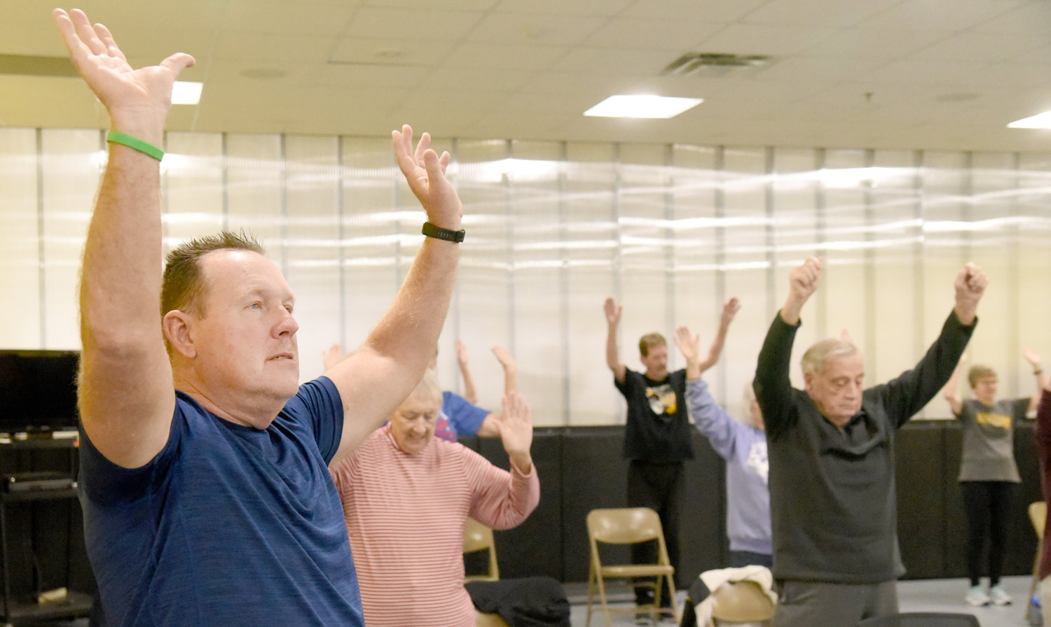 Senior fitness instructor Tom Dickey, left, leads his class in a stretching exercise. See Page 12A for more photos.